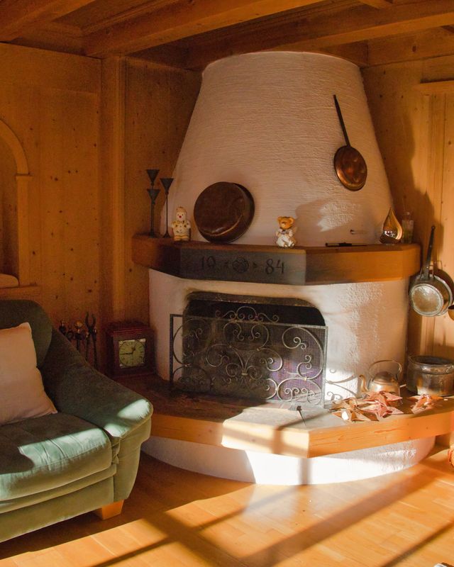 Offener Kamin im Wohnzimmer mit Sessel